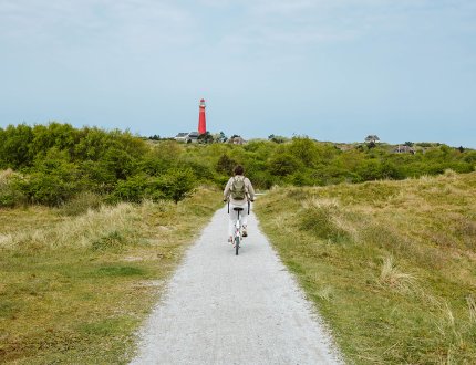 Cyclist on Schiermonnikoog with the lighthouse in view