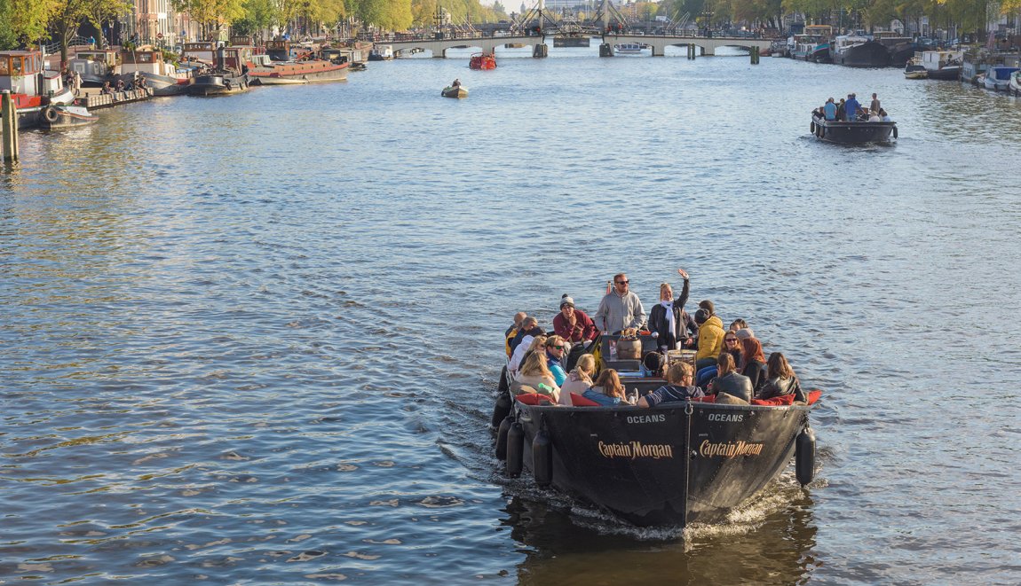 Group of visitors at canal open boat excursion Group of visitors at canal open boat excursion