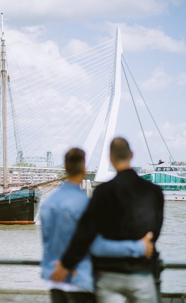 Couple looks arm in arm at the Erasmus Bridge Couple looks arm in arm at the Erasmus Bridge