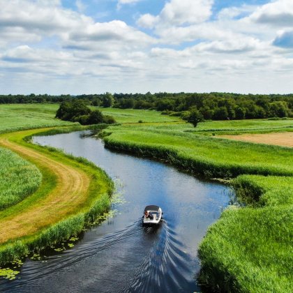 Boat sailing in water through Dutch landscape Boat sailing in water through Dutch landscape