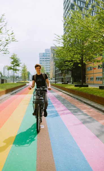 Man bikes across rainbow bike path in Utrecht Man bikes across rainbow bike path in Utrecht