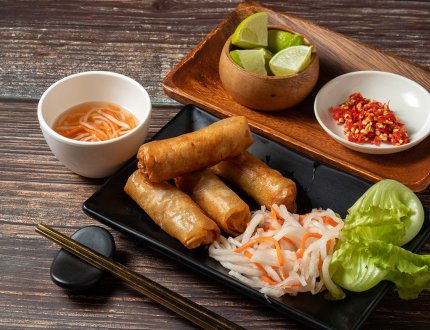 Fried spring rolls with lime and noodles served in bowl isolated on table top view