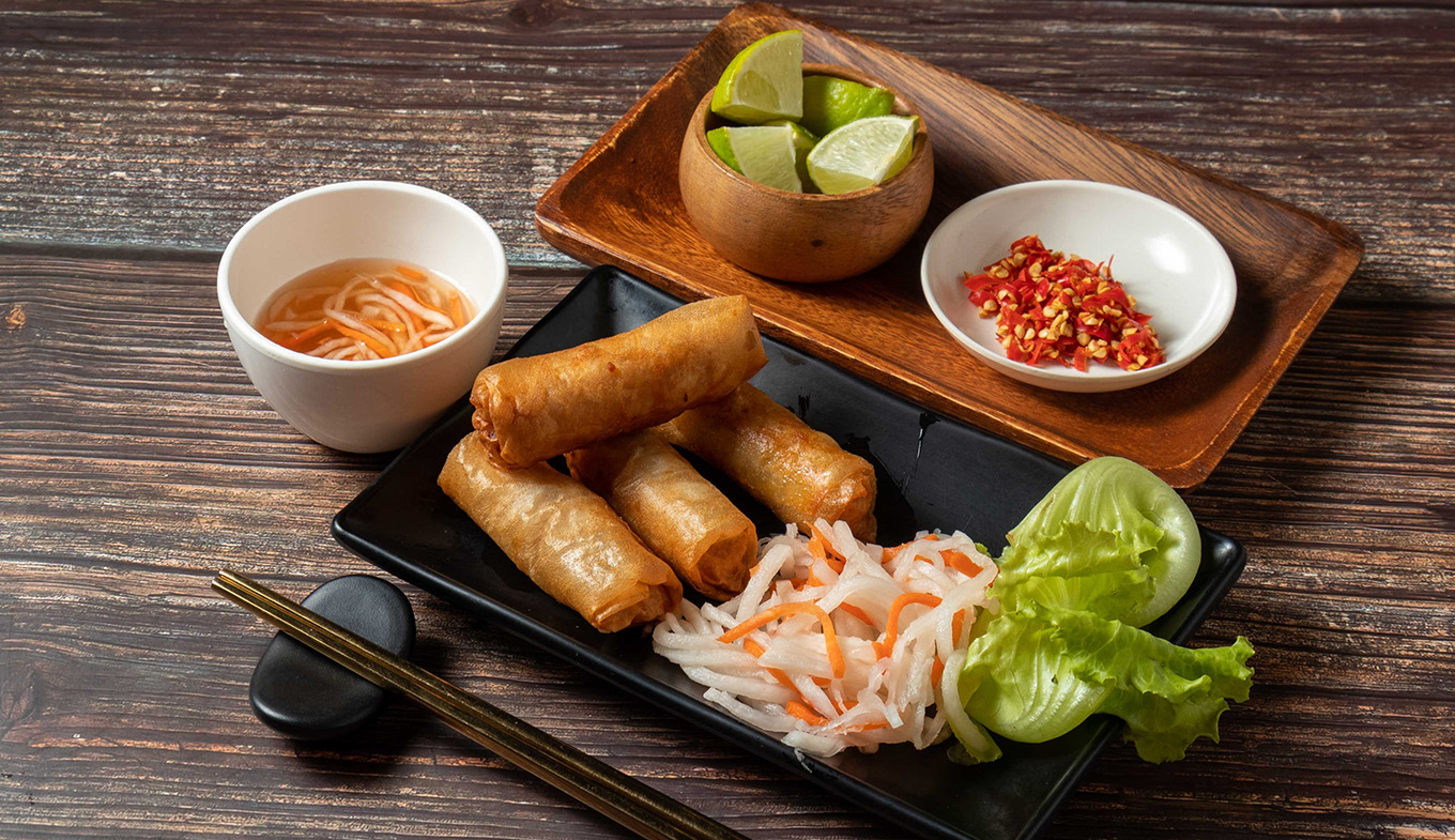 Fried spring rolls with lime and noodles served in bowl isolated on table top view