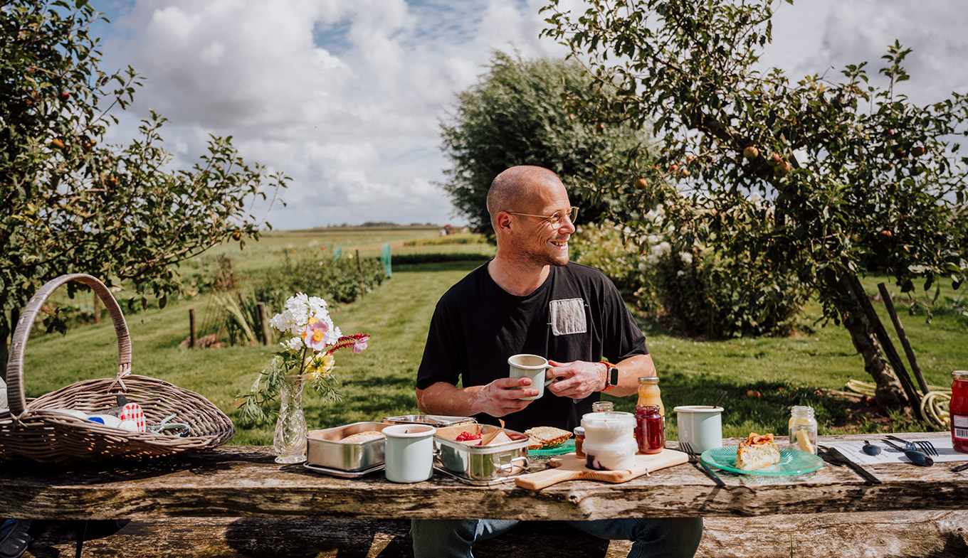 Grune Woche Man picknickt aan tafel bij het Zuiderkrib Dijkhuisje in Kraggenburg, Flevoland