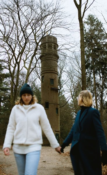 Couple walking hand in hand with the Belvedere Tower Lochemse Berg in the background, Barchem Couple walking hand in hand with the Belvedere Tower Lochemse Berg in the background, Barchem