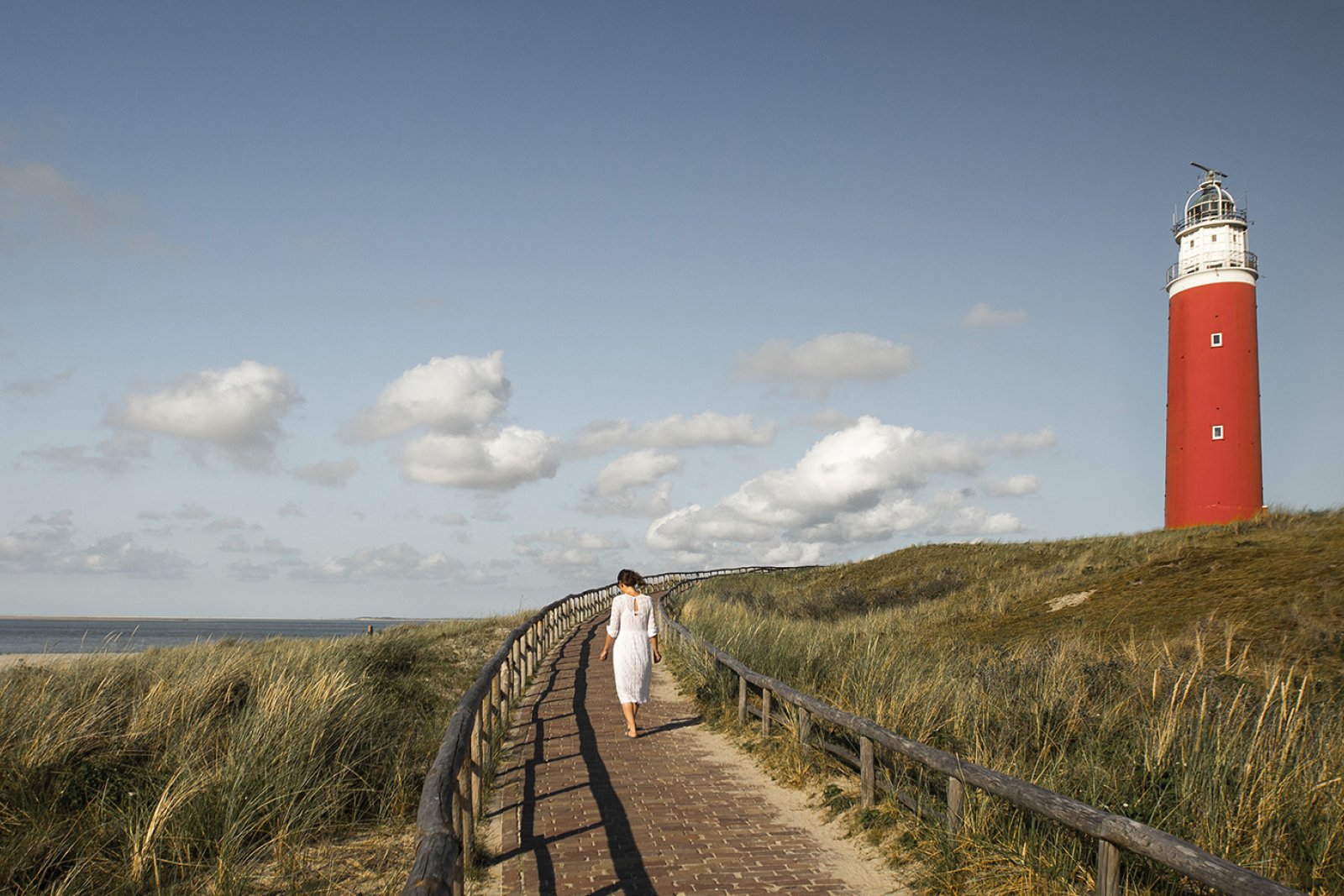 Woman at the Texel lighthouse in summer Woman at the Texel lighthouse in summer